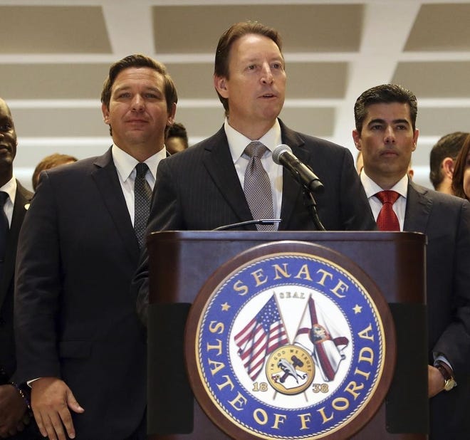 Senate President Bill Galvano, R-Bradenton, flanked by Gov. Ron DeSantis, left, and House Speaker Jose Oliva, R-Miami Lakes, makes some closing remarks at the end of session May 4 in Tallahassee. [AP Photo/Steve Cannon]