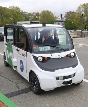 The field autonomy engineer has his hands up to show that he is not driving the vehicle as it comes in to park after taking a spin around the block with the governor and others. The free self-driving shuttle will make runs between the State House and Olneyville Square. [The Providence Journal / Sandor Bodo]