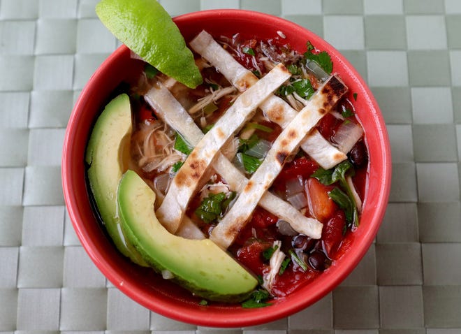 Chicken Tortilla Soup is made with a rotisserie chicken, onions, garlic, jalapeños, tomatoes, black beans, limes and cilantro, and it is garnished with strips of a tortilla and wedges of an avocado. [St. Louis Post-Dispatch / TNS / Hillary Levin]