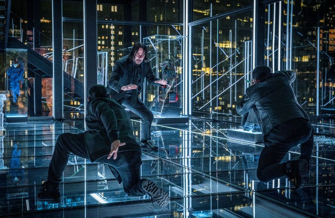 John Wick (Keanu Reeves) gets ready for a battle in - yikes! - a house of glass. [Nico Tavernise]