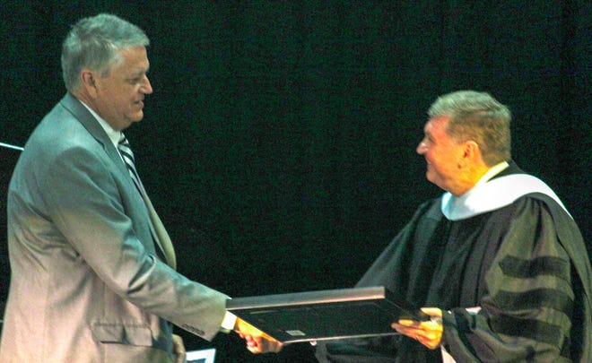 N.C. Sen. Norman Sanderson, left, accepts a 2019 PresidentþÄôs Extraordinary Partnership Award from PCC President Dr. Jim Ross. The presentation took place during the collegeþÄôs Commencement ceremony. [CONTRIBUTED PHOTO]