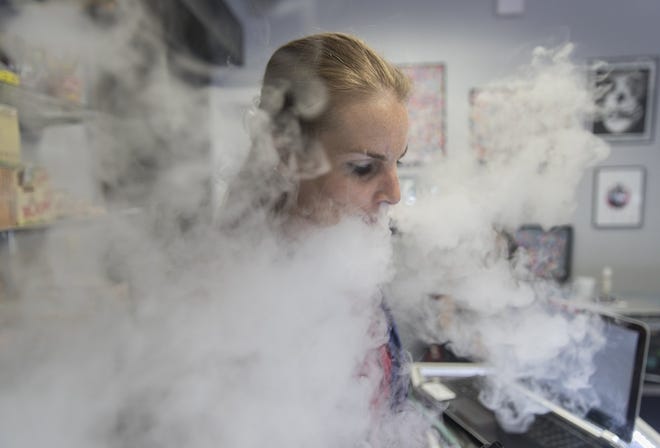 Vape & Smoke employee B. Taylor C. Allbaugh demonstrates an e-cigarette at the South Austin store in 2017. [RICARDO B. BRAZZIELL/AMERICAN-STATESMAN]