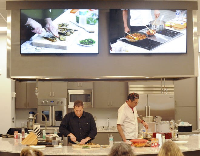 Bourne primary care doctor Miguel Prieto, MD (right) and Upper Cape Cod Regional Technical High School principal Roger Forget demonstrate plant-based cooking in Upper Cape Tech's new demonstration kitchen.



[Ron Schloerb/Cape Cod Times]