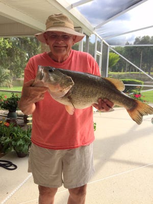 Pat Abernathy shows off a 10-pound largemouth bass he caught recently while fishing in one of the lakes in Plantation Bay. [News-Tribune/Capt. Mike Vickers]