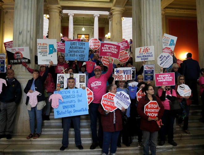 Demonstrators on both sides of an abortion-rights bill fill the Rhode Island State House on Tuesday evening, greeting visitors under the portico.  [The Providence Journal / Kris Craig]