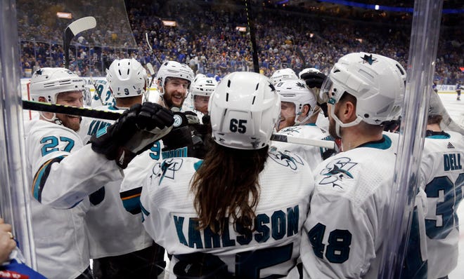 San Jose's Erik Karlsson (65) is congratulated after scoring the winning goal in overtime against the St. Louis Blues in Game 3 of the Western Conference finals Wednesday in St. Louis. [AP Photo/Jeff Roberson]