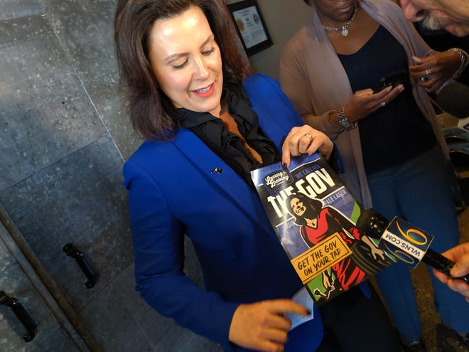 Michigan Gov. Gretchen Whitmer holds up a logo for "The Gov" beer at Lansing Brewing Company on May 14, 2018.
