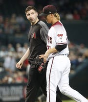 Arizona Diamondbacks starting pitcher Zack Greinke (21) exits the game after an apparent injury after a pitch against the Pittsburgh Pirates as Head Athletic Trainer Ryan DiPanfilo walks with him during the eighth inning at Chase Field in Phoenix, Ariz. May 15, 2019.