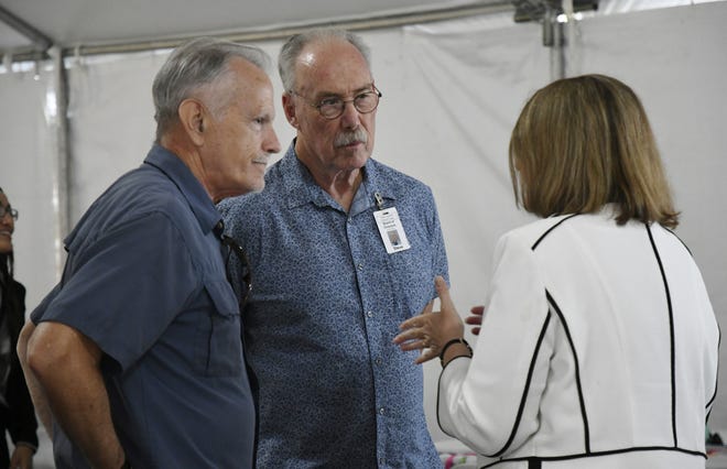 Tulare hospital district President Kevin Northcraft and Director Steven Harrell speak with Andrea Kofl of Adventist Health at a ceremony on Wednesday, May 15, 2019.