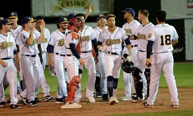 Jordyn Adams (fourth from right) is surrounded by his Burlington Bees teammates after delivering the game-winning single in Thursday's 5-4 win over the Wisconsin Timber Rattlers at Community Field. [Steve Cirinna/Special to The Hawk Eye]