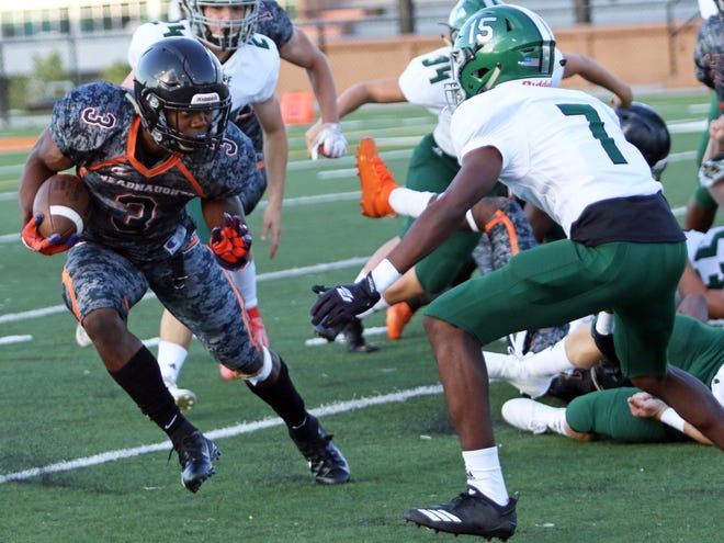 Lakeland running back Demarkcus Bowman looks to make a move against Venice defensive back Steffon Johnson in the first quarter on Thursday night during their spring game at Bryant Stadium. [ROY FUOCO/THE LEDGER]