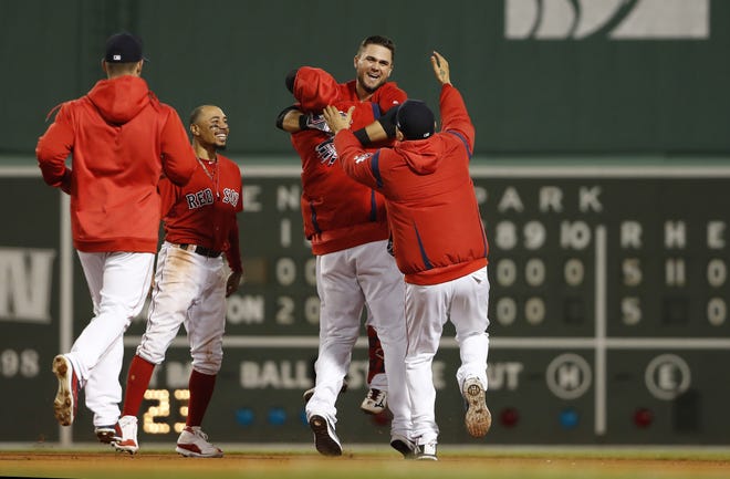 Boston Red Sox rookie Michael Chavis, second from right, is mobbed by teammates after his game-ending RBI single in the 10th inning on Wednesday night against the Colorado Rockies at Fenway Park in Boston. (AP Photo/Winslow Townson)