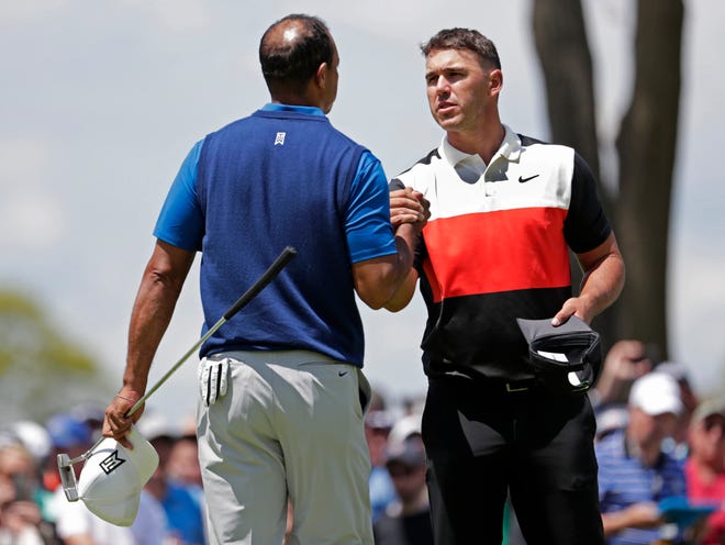 Brooks Koepka, right, shakes hands with Tiger Woods after Koepka finished the first round of the PGA Championship with a 63 Thursday at Bethpage Black in Farmingdale, N.Y. [THE ASSOCIATED PRESS / JULIO CORTEZ]