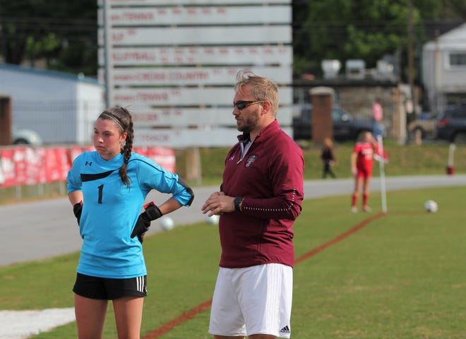 Owen soccer head coach David Fiest meets with senior C.J. Graham before the Warlassies take the field against Hendersonville on May 15.