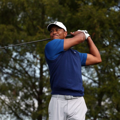First round: Tiger Woods plays his shot from the...