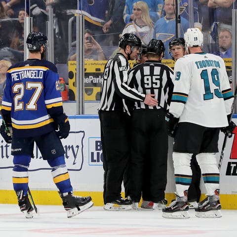 On-ice officials discuss whether they saw a hand...