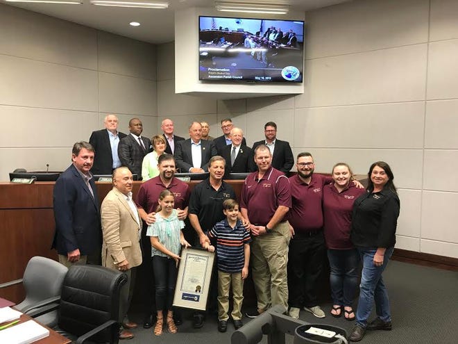 A Ralph's Market and Ascension Parish Council group photo with proclamation of 35 years.