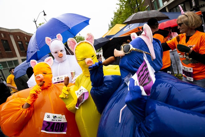 Members of the Wright family from Chatham and Farmer City navigate their costumes to enjoy mini corn dogs at one of the food stops during the Fat Ass 5K & Street Party for Charity along the streets of downtown, Saturday, May 11, 2019, in Springfield. [Justin L. Fowler/The State Journal-Register]