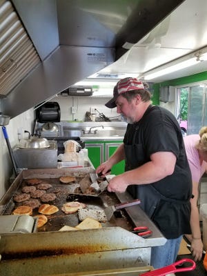 Ted Denning mans a full griddle inside Uncle Ted's Just Darn Good Food truck.