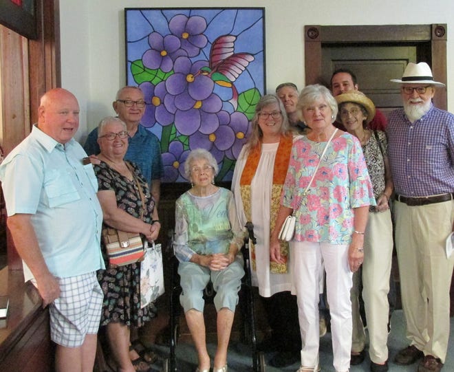 Pastor Leigh McCaffery and a few members of First Congregational United Church of Christ gather around "Winded Beauty," an acrylic painting on wood by Jim Preston, one of the West Volusia artists to participate in the church's Journey to Joy festival. [Photo provided]