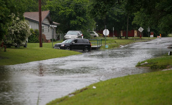 High water is pictured near NW 34th and Hammond in Warr Acres, Okla., after severe storms moved through the metro area, Saturday, May 18, 2019. [Sarah Phipps/The Oklahoman]