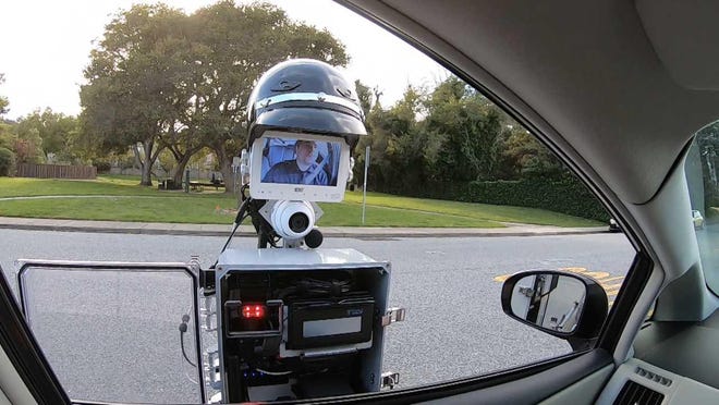 The GoBetween robot, with a helmet on its "head," enables motorists and police officers to communicate electronically. [SRI International]