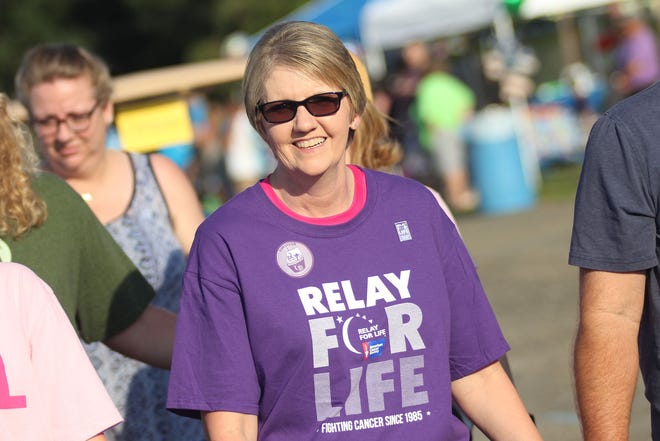 Breast Cancer Survivor Christine Ruff waves and celebrates being cancer free during the survivor walk at Relay for Life held at the Cleveland County Fairgrounds Friday night. [Hannah Dunaway/ Special to The Star]