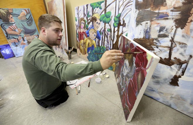 Christopher Billmyer works on an oil painting May 9 at Schmid Innovation Center in Dubuque. Billmyer is a Dubuque native who lost both his legs in an explosion in Aghanistan. After graduating from University of Iowa this spring, he will return to Dubuque to open an art studio. [Jessica Reilly/Telegraph Herald]
