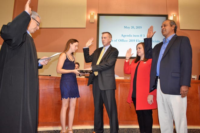 Lakeway Judge Kevin Madison administers the oath of office May 20 to new City Council members Doug Howell, whose daughter is holding a Bible, Gretchen Vance and Sanjeev Kumar. [PHOTO BY LESLEE BASSMAN]