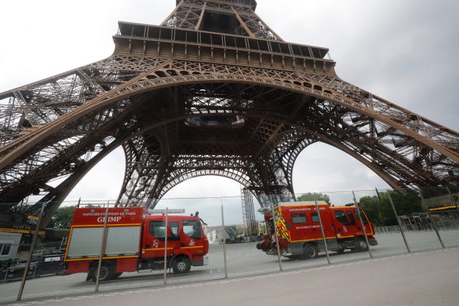 Rescue workers vehicles park just down the Eiffel Tower Monday, May 20, 2019 in Paris. The Eiffel Tower has been closed to visitors after a person has tried to scale it. (AP Photo/Michel Euler)