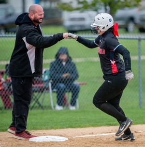 Metamora softball coach Deric Linder, left, pounds fists with Tori DeVore as she rounds third base after hitting a home run in the sixth inning against Illini Bluffs on Saturday, May 11, 2019. [MATT DAYHOFF/JOURNAL STAR]