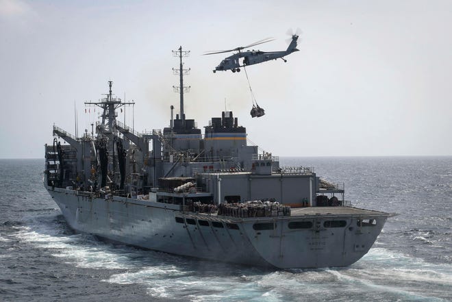 In this Sunday, May 19, 2019, photo released by the U.S. Navy, an MH-60S Sea Hawk helicopter from the "Nightdippers" of Helicopter Sea Combat Squadron 5 transports cargo from the fast combat support ship USNS Arctic to the Nimitz-class aircraft carrier USS Abraham Lincoln during a replenishment-at-sea in the Arabian Sea.(Mass Communication Specialist 3rd Class Jeff Sherman/U.S. Navy via AP)