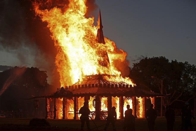 The "Temple of Time" built as a memorial to the 17 victims of a shooting at Marjory Stoneman Douglas High School is seen on fire during a ceremonial burning in Coral Springs Sunday. [John McCall/South Florida Sun-Sentinel via AP]