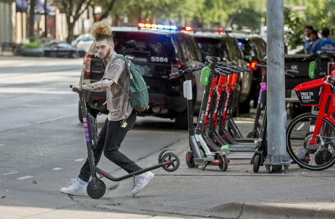 A scooter rider comes to an abrupt halt during an early May trip in downtown Austin. The city of Austin is considering regulating electric rental scooters in much the same way the city regulates taxis. [JAY JANNER/AMERICAN-STATESMAN]
