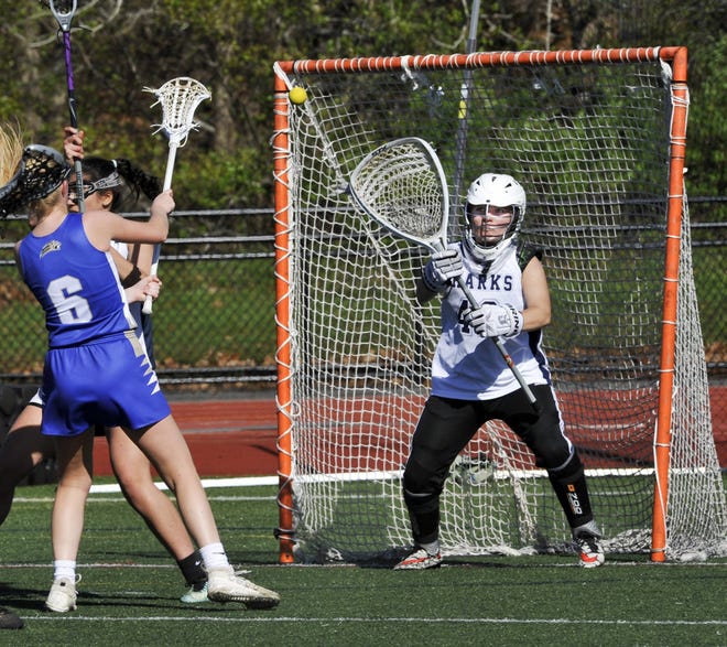 Monomoy goalie Maddie Flaherty tries to get in front of a shot by St. John Paul II's Emily Bach (6) during Tuesday's game in Harwich. Flaherty made the save. [Ron Schloerb/Cape Cod Times]