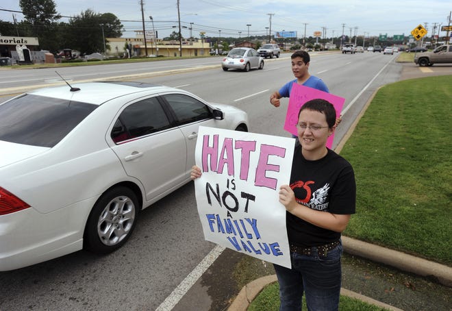 In this Aug. 6, 2012, file photo, Jessica Morgan, 19, and Bobby Ortiz, 18, of Whitehouse, hold signs supporting gay marriage outside of Chick-fil-A in Tyler. Texas Gov. Greg Abbott has signaled he'll sign a contentious measure that Republicans call a defense of Chick-fil-A and religious freedom but was tearfully opposed by gay lawmakers. The Texas House gave final approval to the bill Tuesday. It comes two months after San Antonio City Council members refused to let Chick-fil-A open an airport location. [Sarah A. Miller/Tyler Morning Telegraph via AP, File]