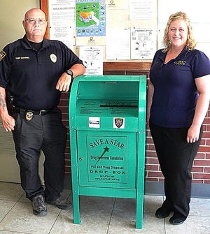 Goshen Police Chief Steve McDaniel and Records Clerk Katie Osberg stand beside the newly installed drug drop box inside the station.