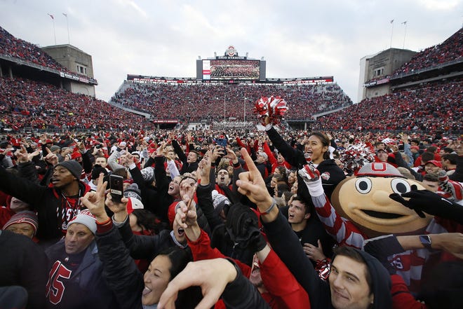 Brutus Buckeye and fellow Ohio State Buckeyes fans rush the field following the NCAA football game against the Michigan Wolverines at Ohio Stadium in Columbus on Nov. 24, 2018. Ohio State won 62-39. [Adam Cairns/Dispatch]