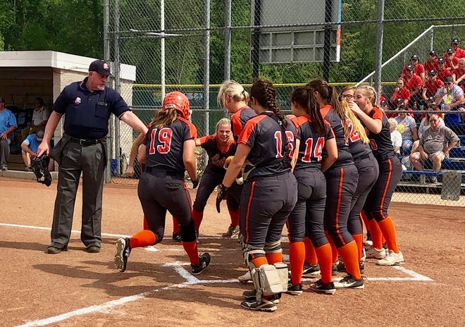 Meadowbrook High's Lynsey Dudley (19) is greeted by her teammates at home plate after belting a two-run home run in the first inning of Wednesday's Division III fegional semifinal game against Garaway at Lancaster. The Lady Colts posted a 14-9 win to advance to Saturday's regional championship game.
