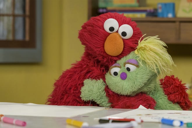 Elmo hugs Karli, his new friend. [ZACH HYMAN/SESAME WORKSHOP]