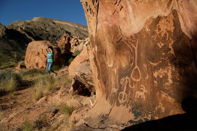FILE - In this May 26, 2017, photo, Susie Gelbart walks near petroglyphs at the Gold Butte National Monument near Bunkerville, Nev. U.S. Interior Secretary David Bernhardt says he has no plans for additional changes to Gold Butte and other national monuments as recommended by his predecessor, but says it's ultimately up to President Donald Trump. (AP Photo/John Locher, File)