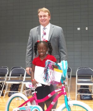Mike Cihla, news anchor from WTOC and master of ceremonies, with Mauri McClow from Springfield Elementary School. She had the highest score and won a new bike and helmet. [COURTESY EXCHANGE CLUB]