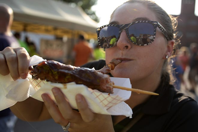 Mackenzie Cauthon of Roseville savors a bite of bacon-wrapped pork during the 2018 Monmouth BaconFest. [STEVE DAVIS/GATEHOUSE MEDIA]