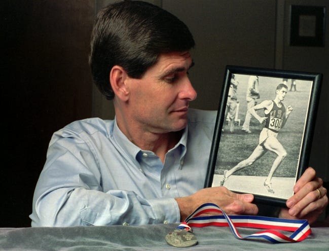 Former Olympian Jim Ryun looks at a photograph taken of him in 1968 Olympics in Mexico City where he won a silver medal, foreground, in the 1,500-meter run, at his home in Lawrence, Kansas in 1991. [AP file Photo/Jeff Carney]