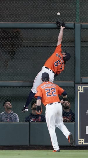 Astros center fielder Jake Marisnick leaps in an attempt to catch a long fly ball that went for a double by the Red Sox' Mookie Betts in the fourth inning of Friday night's game. [AP / David J. Phillip]