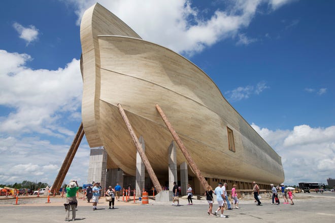 FILE - In this July 5, 2016, file photo, visitors pass outside the front of a replica Noah's Ark at the Ark Encounter theme park during a media preview day, in Williamstown, Ky. In the Bible, the ark survived an epic flood. Yet the owners of Kentucky’s Noah’s ark attraction are demanding their insurance company rescue them from flooding that caused nearly $1 million in property damage. (AP Photo/John Minchillo, File)