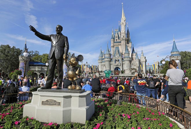 Guests watch a show near a statue of Walt Disney and Micky Mouse in front of the Cinderella Castle at the Magic Kingdom at Walt Disney World in Lake Buena Vista, part of the Orlando area in Fla., on Jan. 9, 2019. Magic Kingdom was the best-attended park in 2018 with 20.8 million visitors, followed by Disneyland in California with 18.6 million visitors. [AP Photo/John Raoux, File]