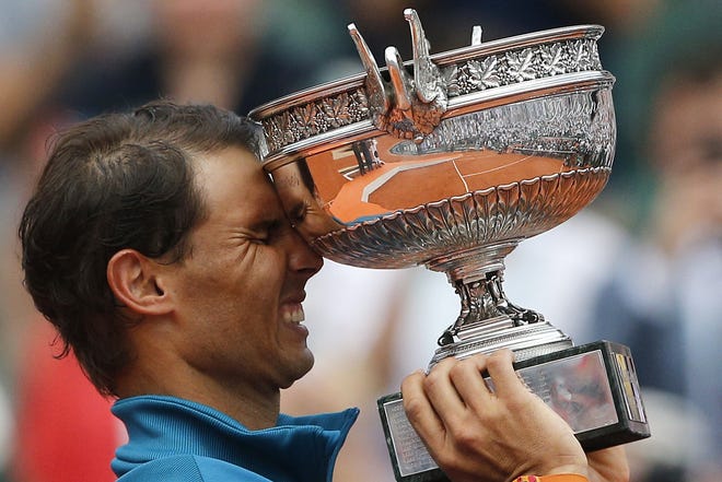 Spain's Rafael Nadal reacts while holding the trophy after defeating Austria's Dominic Thiem in the men's finals of the French Open on June 10, 2018, in Paris. [AP Photo/Thibault Camus, File]