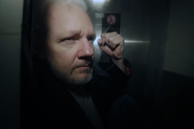 WikiLeaks founder Julian Assange puts his fist up as he is taken from court on May 1 in London. The Justice Department has charged Assange with receiving and publishing classified information. [AP Photo/Matt Dunham, File]