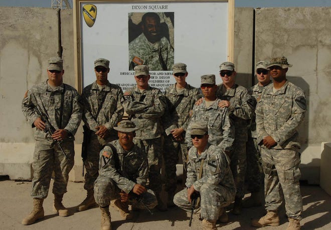 Members of the Personal Security Detachment, 3rd Brigade Combat Team, 1st Cavalry Division, stand in front of the picture of Staff Sgt. Donnie Dixon during the dedication ceremony of the Dixon Square, Nov. 22, 2007. Dixon, who died of wounds received in combat Sept. 29, was a member of the PSD, serving to protect the lives of his command and his comrades.
